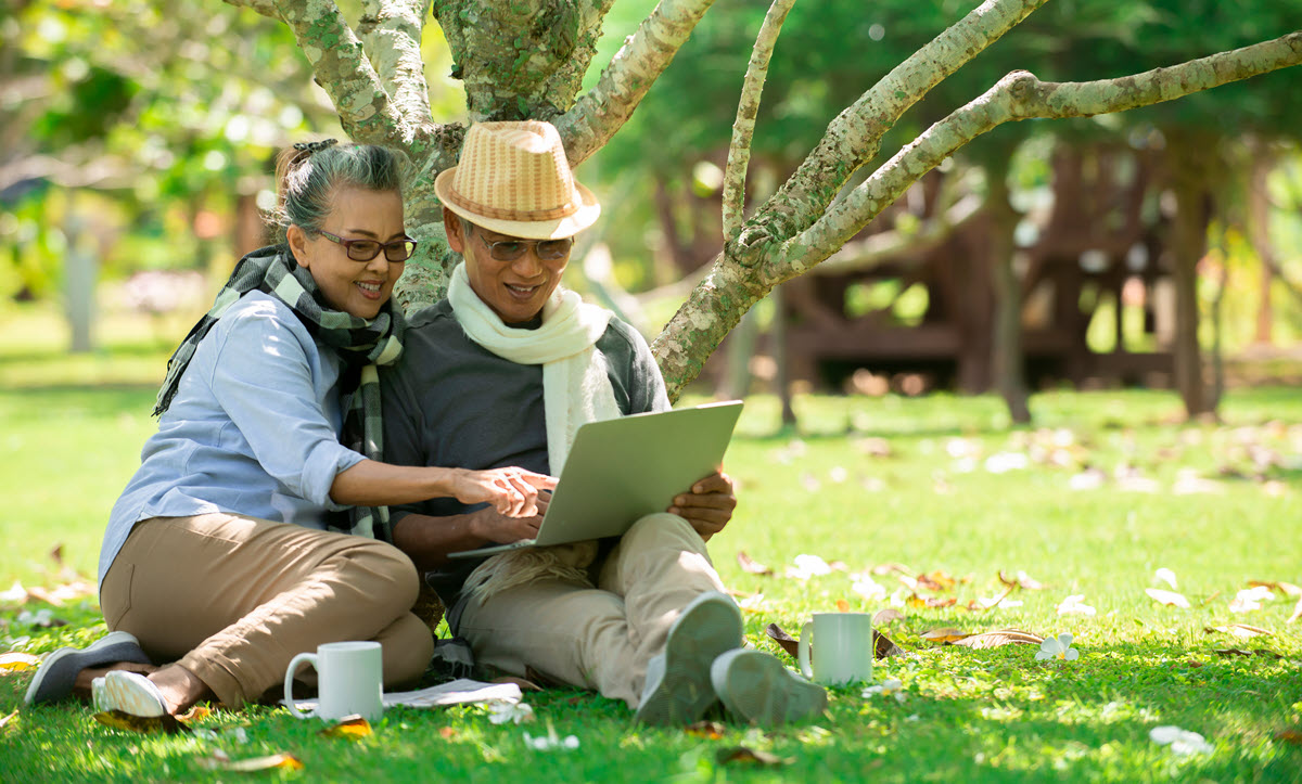 two expats looking at international retirement plans online while outside