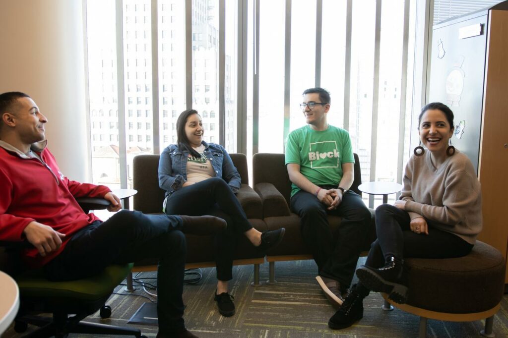 Four associates sit and chat